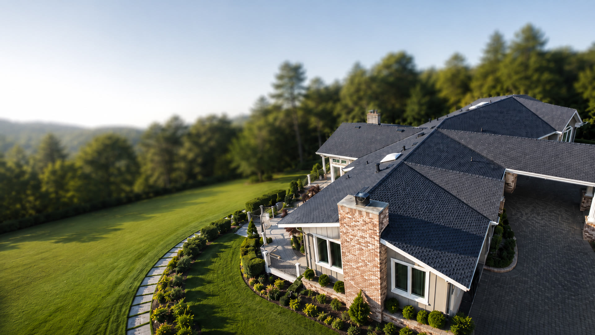 Aerial view of a luxury home with a new charcoal architectural shingle roof installed by RoofCraft