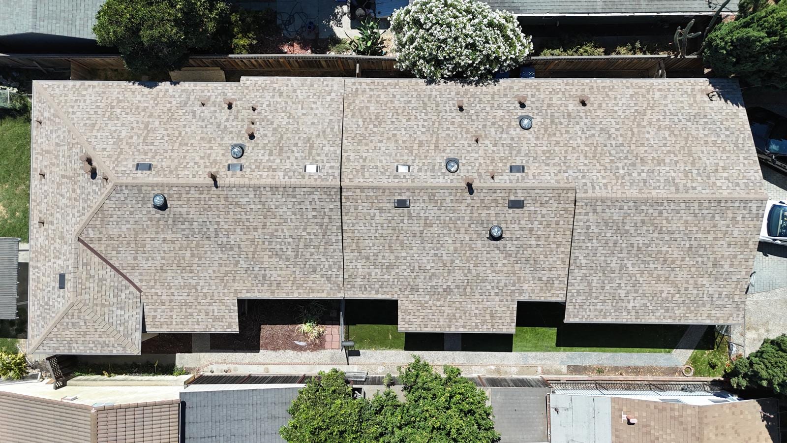 Tan Shingle Reroof and Re-Deck on a Long Tudor-Style Building