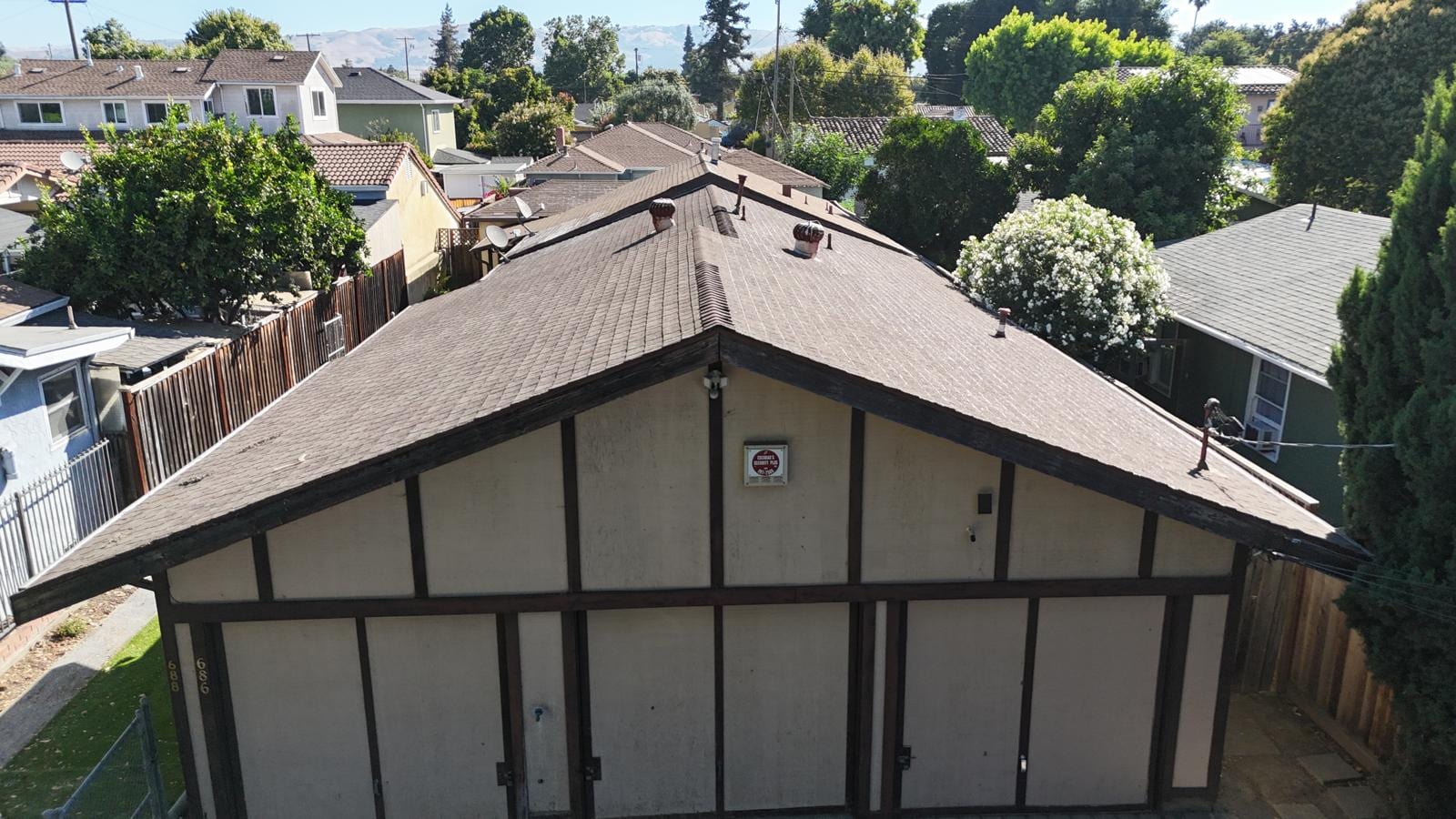 Tan Shingle Reroof and Re-Deck on a Long Tudor-Style Building — before