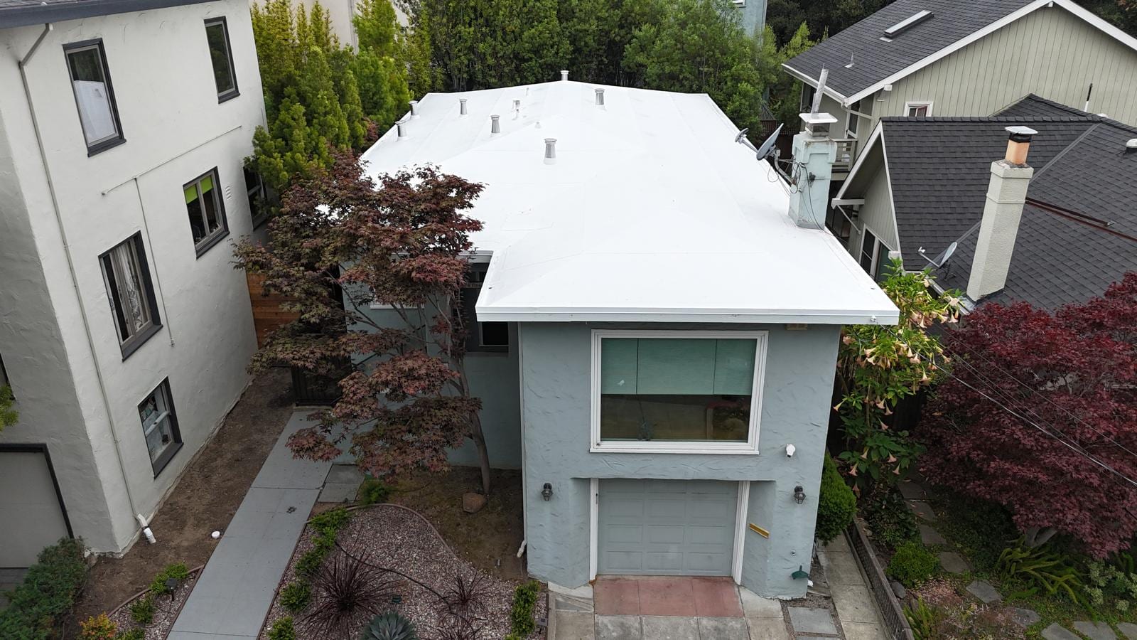 White Flat Roof Replacement on a Blue-Green Home