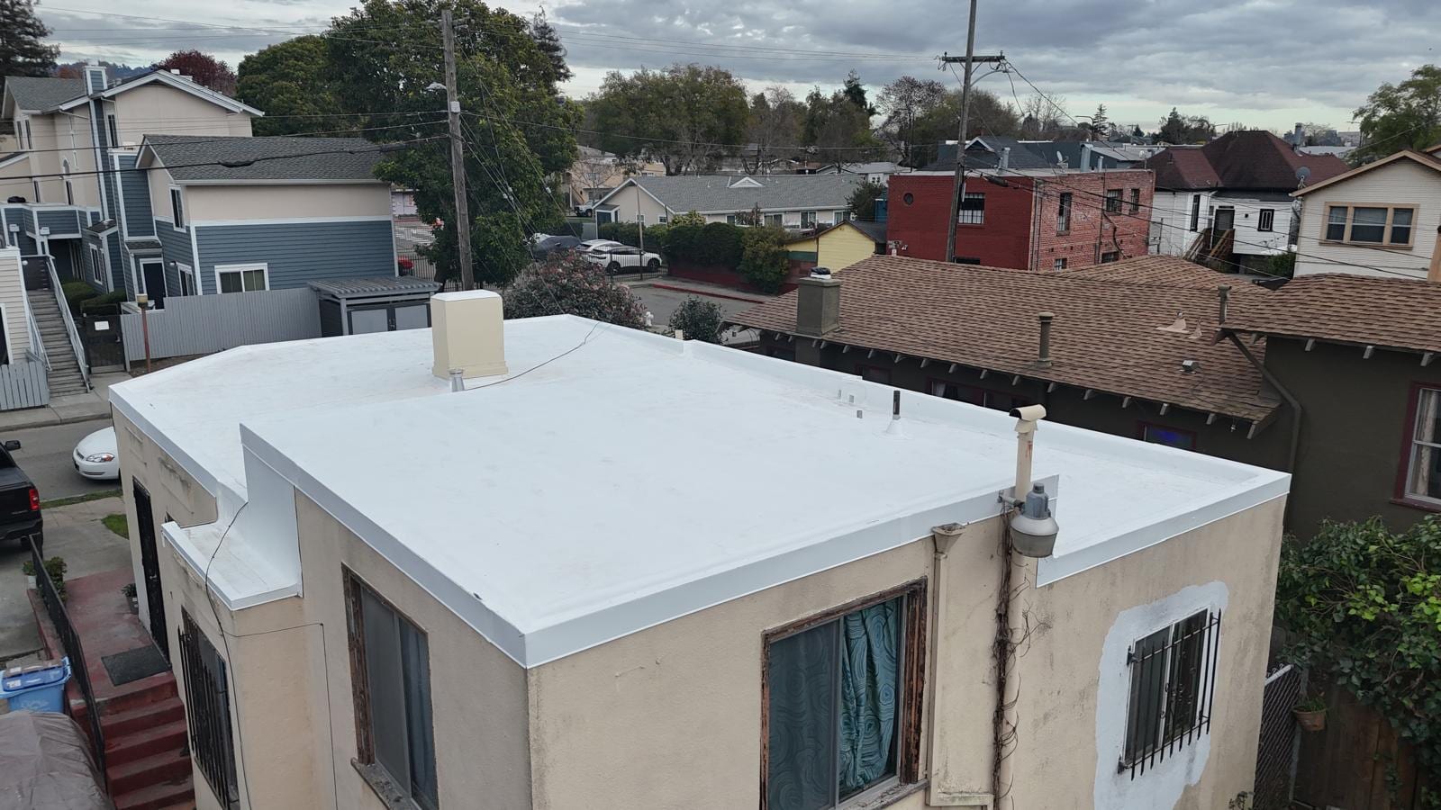 White Coated Flat Roof on a Stucco Home